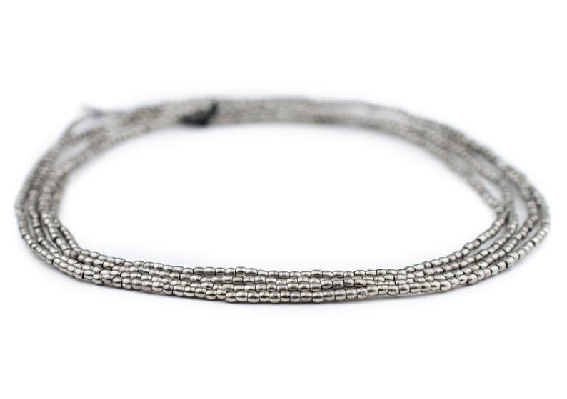 May include: A silver beaded necklace with multiple strands. The beads are small and round, creating a delicate and elegant look.
