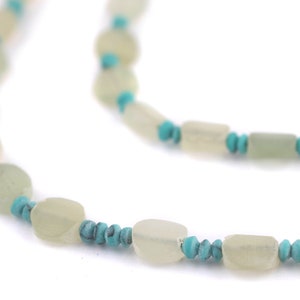 May include: A necklace made of light green and turquoise beads. The beads are oval and round in shape.