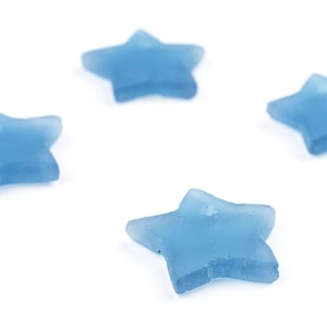 May include: Four light blue star-shaped glass beads on a white background.