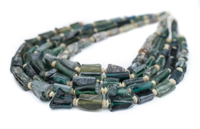 May include: A multi-strand necklace made of dark green and light blue glass beads. The beads are irregular in shape and size, and some have a slightly iridescent finish.