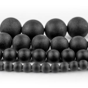 May include: A set of black matte round beads in various sizes. The beads are arranged in rows, with the largest beads at the top and the smallest beads at the bottom.