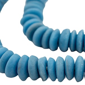 May include: A strand of light blue glass beads, each bead is shaped like a flattened oval with a slightly rounded edge.