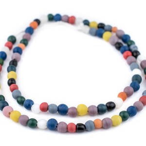 Puede incluir: Dos hilos de collares de cuentas de colores. Las cuentas son redondas y vienen en una variedad de colores, incluyendo rojo, azul, verde, amarillo y blanco. Los collares se muestran sobre un fondo blanco.