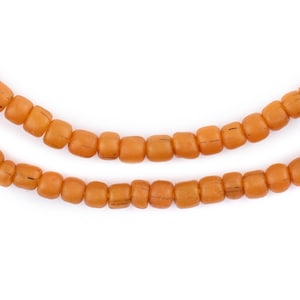 K&ouml;nnte beinhalten: Eine Schnur aus braunen Glasperlen, leicht abgerundet, auf wei&szlig;em Hintergrund aufgereiht.