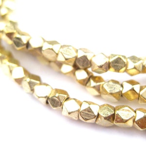 May include: A strand of gold-colored faceted beads. The beads are small and have a slightly irregular shape.