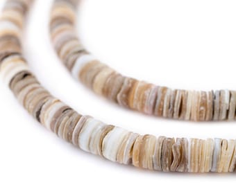 Op de afbeelding: Een close-up van een ketting gemaakt van natuurlijke schelp kralen. De kralen zijn een mix van wit en bruin en zijn gerangschikt in een cirkelvormig patroon. De ketting ligt op een witte achtergrond.