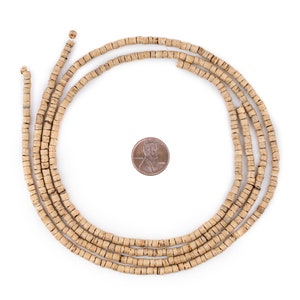 Puede incluir: Una hebra de cuentas de madera de color marr&oacute;n claro, aproximadamente del tama&ntilde;o de una moneda de un c&eacute;ntimo de euro, dispuestas en c&iacute;rculo.