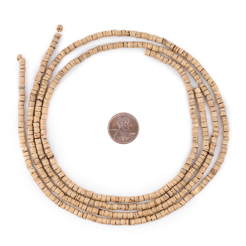 Puede incluir: Una hebra de cuentas de madera de color marr&oacute;n claro, aproximadamente del tama&ntilde;o de una moneda de un c&eacute;ntimo de euro, dispuestas en c&iacute;rculo.