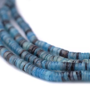 May include: Close-up of multiple strands of blue and gray disc-shaped beads. The beads have a layered appearance, with varying shades of blue and gray. The background is white, highlighting the beads' colors and textures. The beads are likely for jewelry making.