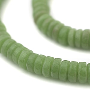 May include: A strand of green jade beads, each bead is a flat, rounded disc with a slightly irregular shape.
