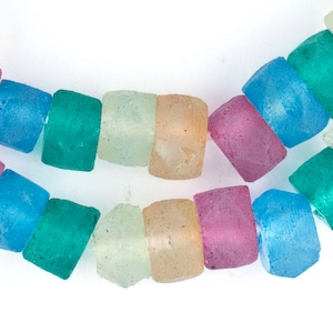 May include: A strand of colorful glass beads in shades of blue, green, pink, and beige. The beads are opaque and have a slightly frosted finish.