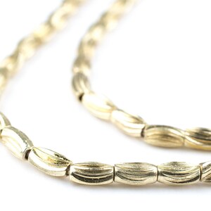 May include: A gold chain necklace with a wavy, textured design. The chain is made of small, oval-shaped links.