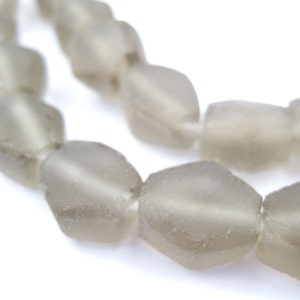 以下が含まれることがあります： 面取りされた楕円形の灰色のガラスビーズのストランド。ビーズは透明な糸に糸で通されています。