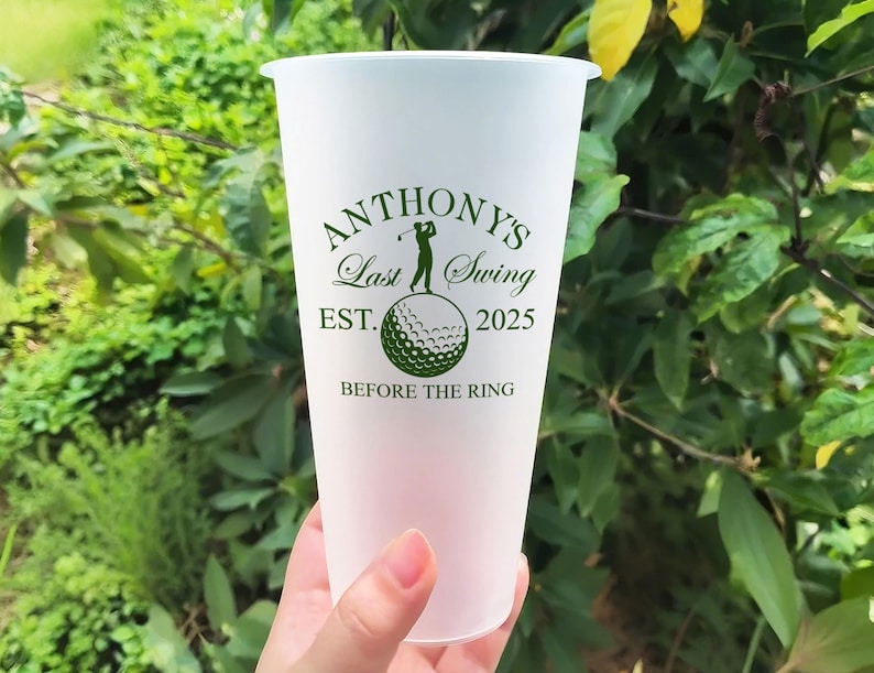 May include: White frosted tumbler with a green graphic that says "Anthony's Last Swing Est. 2025 Before the Ring". The graphic also includes a golfer hitting a golf ball.