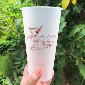 Puede incluir: Vaso de plástico blanco con un diseño rojo de una copa de martini con cerezas y el texto "Stole this from Melissa's Birthday Party".