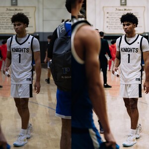 May include: A basketball player wearing a white jersey with black trim and the word "KNIGHTS" and the number "1" on the front. The player is wearing white shorts with black trim and white sneakers.