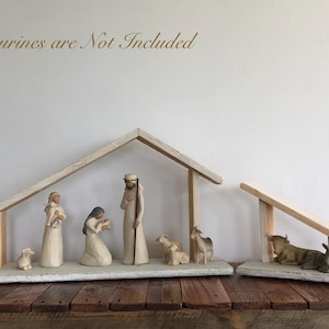 May include: A wooden nativity scene with a light-colored base and a simple roof structure. The scene includes figurines of Mary, Joseph, and other figures. The text "Figurines are Not Included" is visible above the scene.