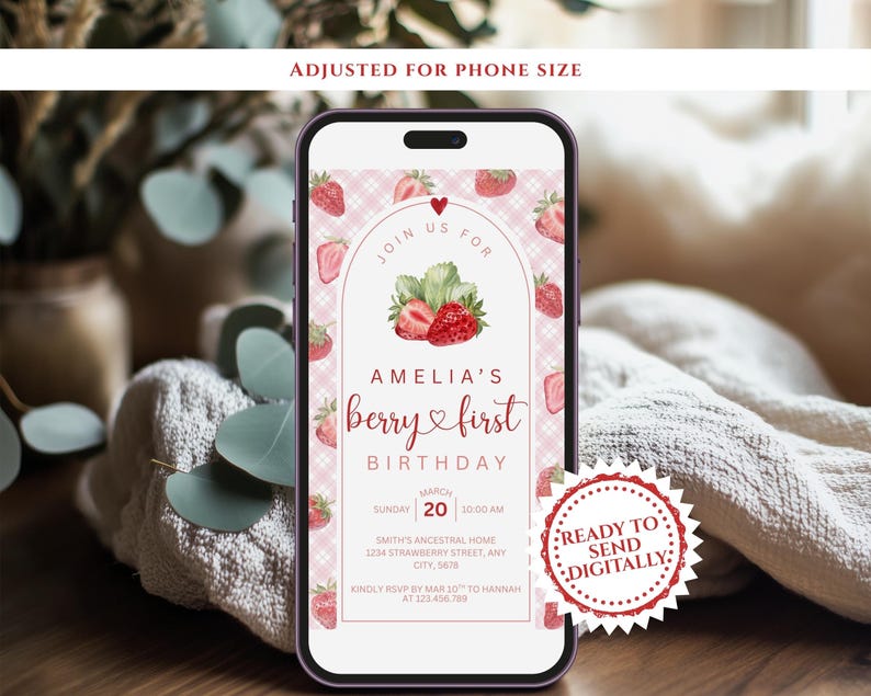 May include: A smartphone displays a digital invitation for Amelia's first birthday. The invitation features a strawberry theme with the text "berry & first birthday." The design includes strawberries, leaves, and a pink gingham pattern. The invitation is ready to send digitally.