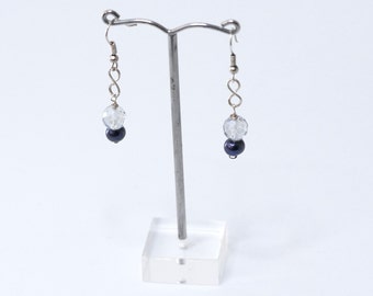 May include: A pair of silver dangle earrings with a clear faceted bead and a dark blue pearl bead on each earring.