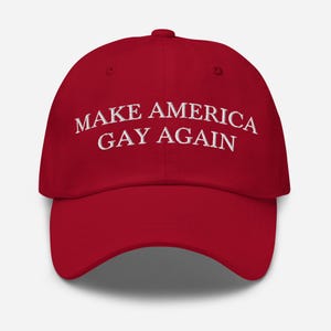 May include: Red baseball cap with white embroidered text that reads "Make America Gay Again".