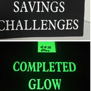 May include: Black fabric with the words "COMPLETED SAVINGS CHALLENGES" in white. Below, the words "COMPLETED GLOW CHALLENGES" glow in green. A small green tag with text is visible.