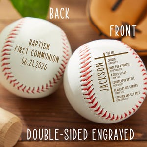 May include: Two white baseballs with red stitching. One baseball has "Baptism First Communion 06.21.2026" printed on it. The other baseball has "Jackson" and religious text printed on it. The words "Back", "Front", and "Double-Sided Engraved" are also visible.