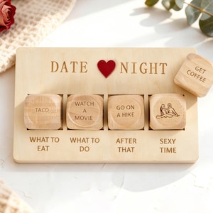 Può includere: Gioco da serata romantica in legno con testo inciso e un cuore rosso. La tavola ha quattro slot con dadi di legno che dicono "Taco", "Guarda un film", "Fai un'escursione" e "Sexy Time". Un dado separato dice "Prendi un caffè".
