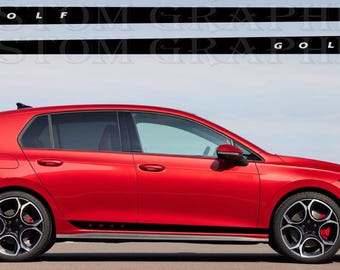 May include: A red hatchback car with black accents and rims. The car has black side decals with the word "GOLF" in white. The car is parked on a road with a blue sky in the background. The car's wheels have a black and silver design.
