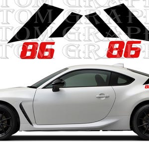 Può includere: Auto sportiva bianca con ruote e finiture nere. L'auto presenta una grafica rossa "86" sul lato e sul retro. Sopra l'auto ci sono elementi grafici neri e le parole "CUSTOM GRAPHICS" in un motivo ripetuto.