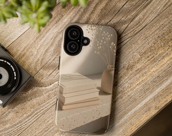 May include: A smartphone case featuring a printed image of a stack of three beige books and a small vase with dried stems on a textured surface. The case has a black camera cutout area with two circular lenses and a small flash opening.