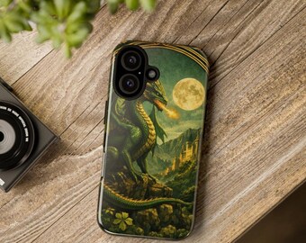 May include: A rectangular smartphone case featuring a green dragon perched on a rocky cliff, breathing fire toward a distant castle under a full moon. The design includes dark green and gold tones, with a dual-lens camera cutout at the top.