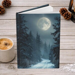 May include: A hardcover book featuring a full-color cover illustration of a snowy forest path at night under a large, bright full moon. The scene depicts dark evergreen trees covered in snow, a winding path, and a glowing moon in the sky.