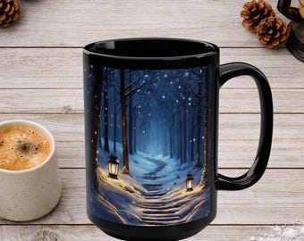 May include: A black ceramic mug featuring a printed illustration of a snow-covered path winding through a dark blue forest at night. Two glowing lanterns illuminate the snowy steps, while small white lights are scattered among the trees.