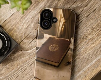 May include: A smartphone case featuring a printed image of a brown leather-bound book with a gold embossed crest on the cover, resting on a desk next to a pen, with a camera lens cutout visible at the top of the protective cover.