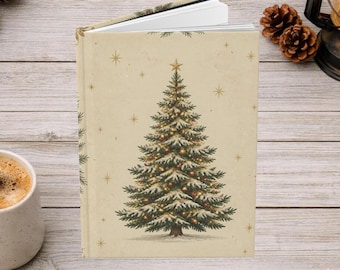 May include: A hardcover journal with a cream-colored cover featuring a central illustration of a snow-dusted Christmas tree decorated with small ornaments and surrounded by gold-colored star accents against a plain background.