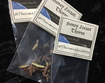 May include: Three small bags of dried honey locust thorns. Each bag has a white label with black text that reads "Honey Locust Thorns", "Thorne's World", and a social media handle.