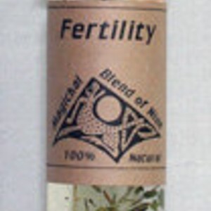 May include: A small glass bottle with a black cap, labeled "Fertility." The label is brown with white text and a geometric design. The bottle contains a clear liquid with herbs and seeds.