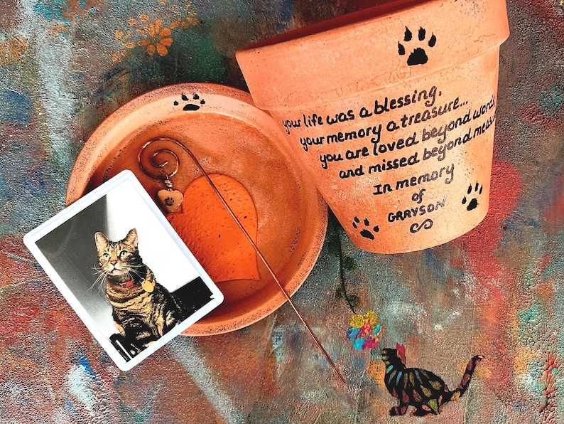 Hand-painted personalized pet memorial planter with custom wording and colors. Terracotta sympathy pot with pet name for dog or cat loss, Rainbow Bridge tribute.  Shown in orange.