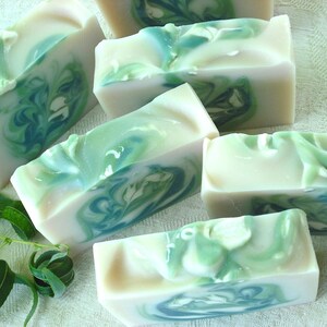 May include: Five bars of handmade soap with a swirling green and white pattern. The soap is made with natural ingredients and is perfect for sensitive skin.