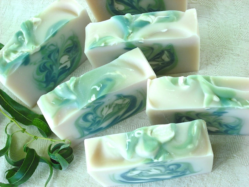 May include: Five bars of handmade soap with a swirling green and white pattern. The soap is made with natural ingredients and is perfect for sensitive skin.