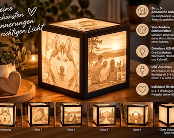 Könnte beinhalten: Eine schwarze, würfelförmige Lampe mit anpassbaren Fotopaneelen an den Seiten. Die Lampe strahlt ein warmes Licht aus, das Bilder eines Huskys, einer Familie und Landschaften beleuchtet. Sie hat eine quadratische Basis und ein USB-Stromkabel.