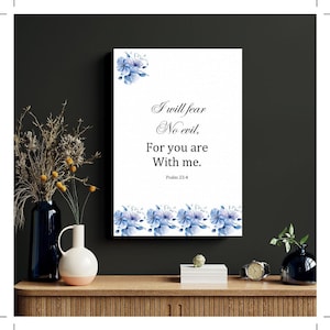 Może przedstawiać: Biały nadruk na płótnie z napisem "I will fear no evil. For you are with me. Psalm 23:4". Ozdobiony niebieskimi akwarelowymi motywami kwiatowymi. Dekoracyjny element do domu, o tematyce religijnej.