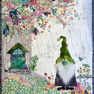 May include: A green gnome with a white beard stands in front of a small green house with a heart-shaped window. The gnome is wearing a green hat and a black outfit. The house is surrounded by green and brown foliage.