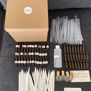 May include: A perfume making kit with a brown cardboard box, small brown glass bottles, clear pipettes, a clear bottle, and perfume testing strips. The kit includes small glass bottles with gold lids and a card with text.