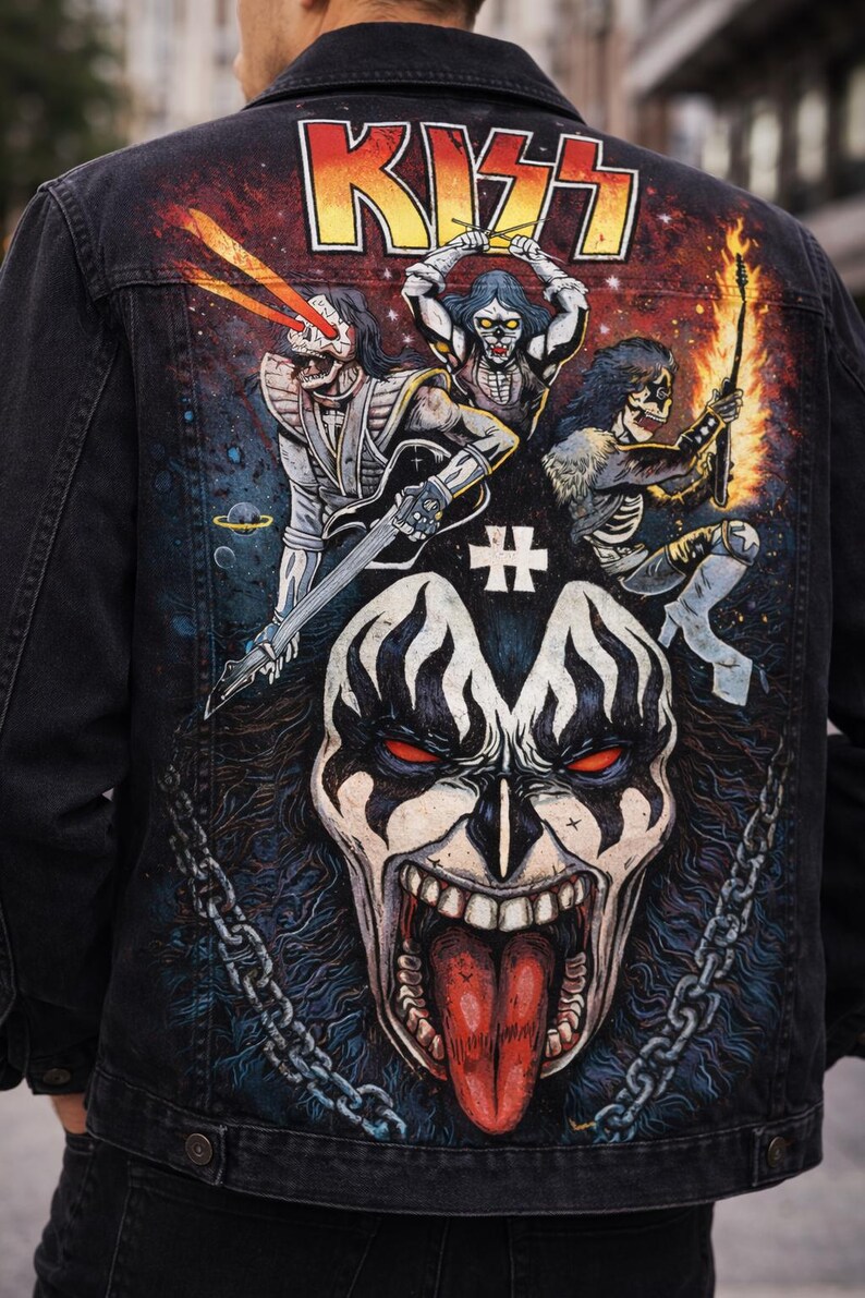 May include: Black denim jacket featuring a colorful graphic of the band KISS. The design includes the band's logo, band members in makeup, and a large face graphic. The jacket has a classic collar and button closure.