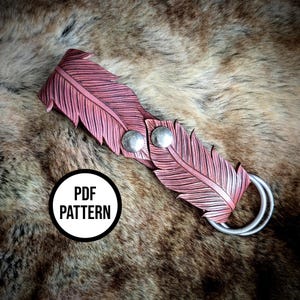 May include: A pink leather bracelet with a feather design. The bracelet has two silver-colored snaps and a silver-colored ring. The text "PDF PATTERN" is in a white circle with a black border.