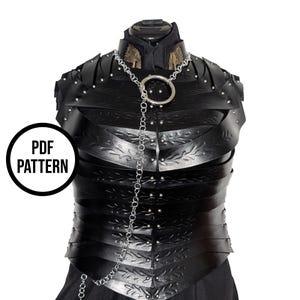 May include: Black leather armor with riveted accents and decorative leaf patterns. A silver chain with a large ring hangs from the neckline. The image includes a circular graphic that says "PDF PATTERN".