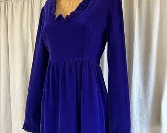 Peut inclure: Une robe longue en velours bleu royal à manches longues, avec un col et des poignets à volants. La robe a un corsage ajusté et une jupe ample.