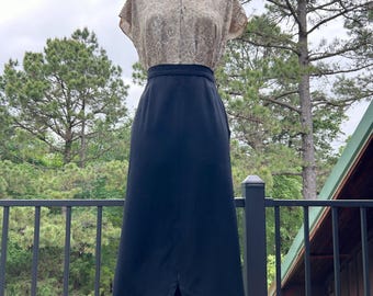 Falda lápiz vintage de los años 50 de gabardina de lana negra con talle alto y frente festoneado. Talla S.