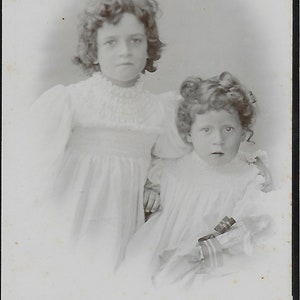 Scheda armadio vittoriano con 2 bambine in bianco, capelli ricci scuri, bambini angelici, amore fraterno, storia sociale della moda vittoriana